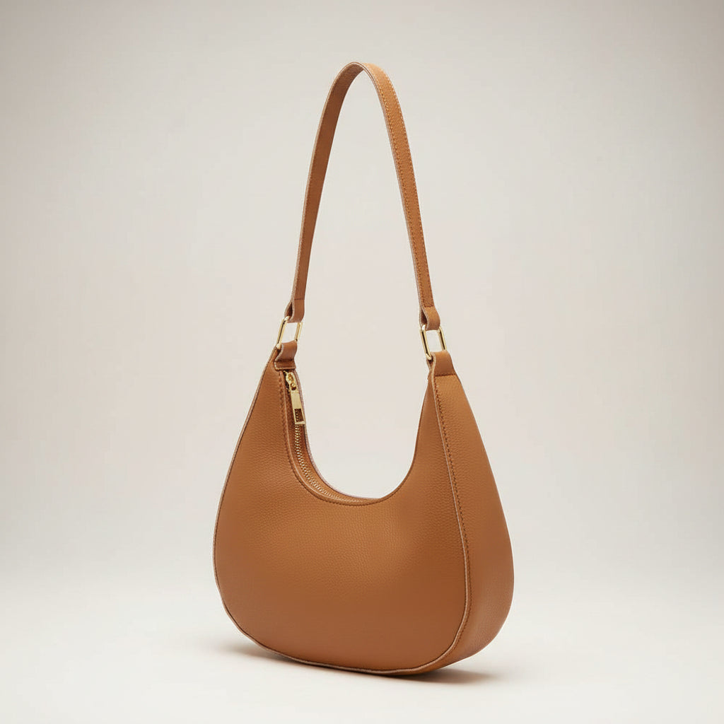 Brown leather handbag with a strap on a white background