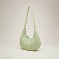 Light green handbag with a strap on a white background